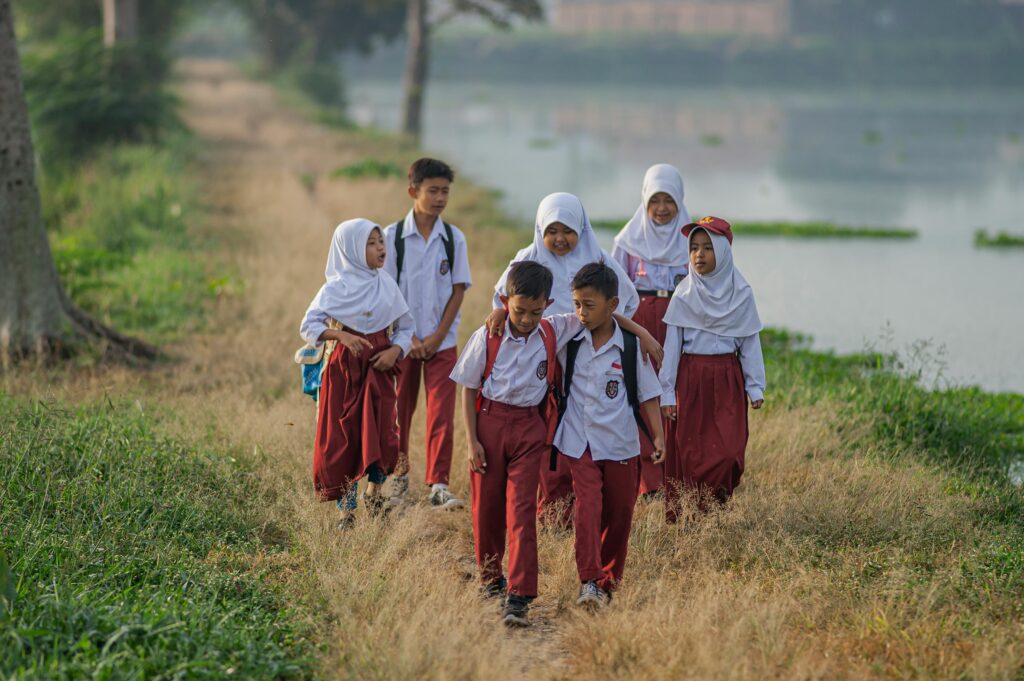 pexels photo 32218913 32218913 Group of children in school uniforms walking along a rural path in West Java, Indonesia.